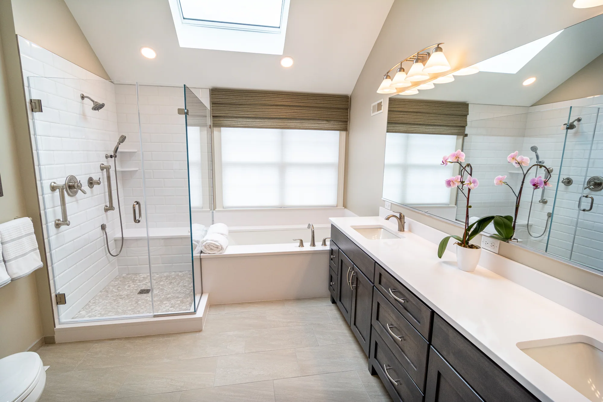 A bathroom remodeled by Danken, lit by a skylight
